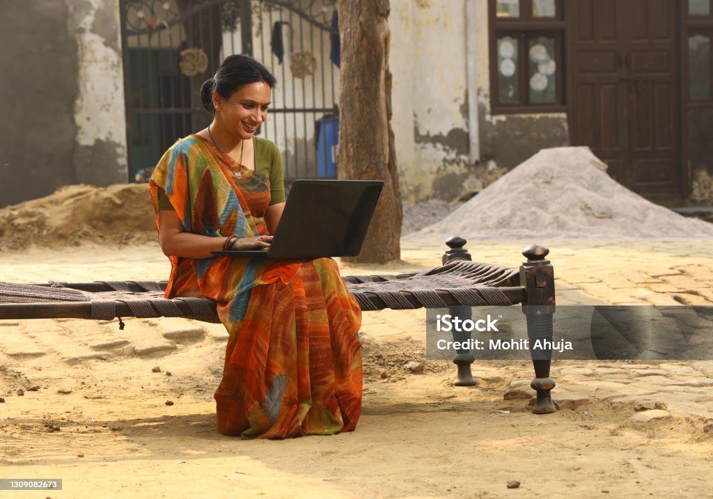 Indian Happy rural women working on laptop in village. she is working with confidence